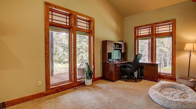 office with light colored carpet, vaulted ceiling, and plenty of natural light