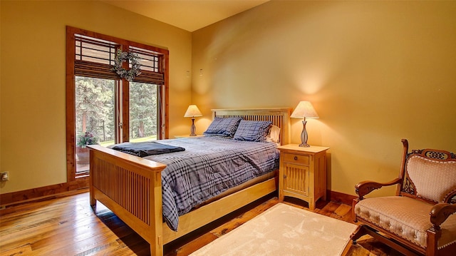 bedroom with hardwood / wood-style flooring and access to exterior