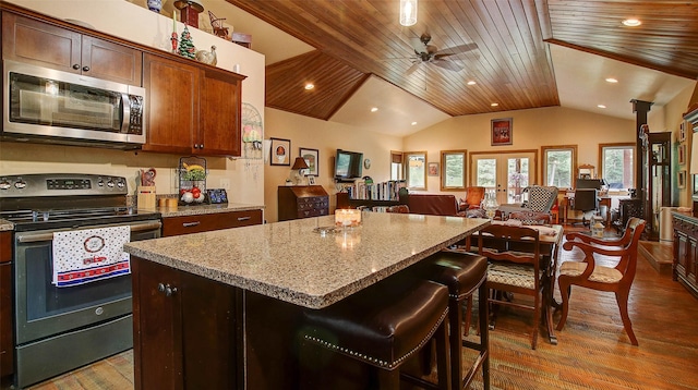 kitchen with hardwood / wood-style floors, a center island, ceiling fan, wood ceiling, and stainless steel appliances