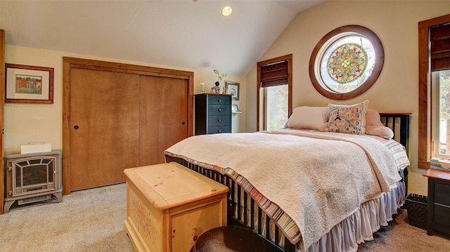 bedroom with light carpet, heating unit, and lofted ceiling