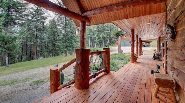 wooden deck featuring a garage and a lawn