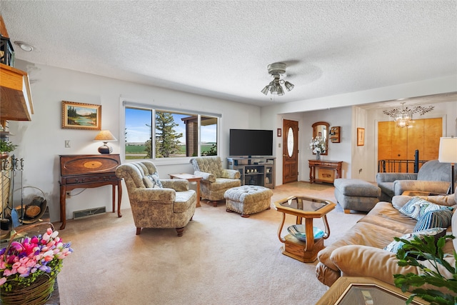 living room featuring carpet floors, a textured ceiling, and ceiling fan with notable chandelier