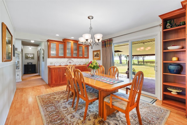 dining area featuring light wood-type flooring and an inviting chandelier