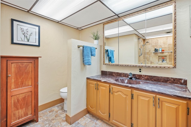 bathroom with tile patterned floors, toilet, vanity, and a tile shower