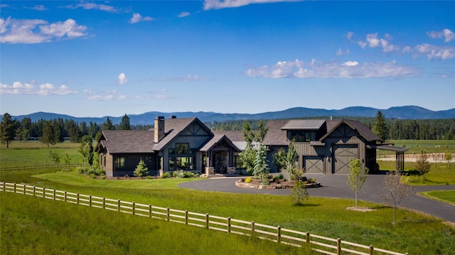 view of front of home featuring a mountain view, a rural view, a garage, and a front yard