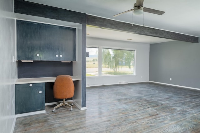 unfurnished office featuring hardwood / wood-style flooring, built in desk, and ceiling fan