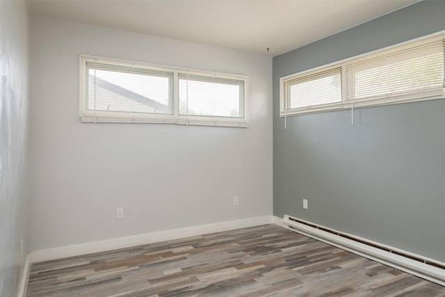 unfurnished room featuring light wood-type flooring, plenty of natural light, and baseboard heating