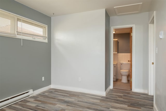 unfurnished room with a baseboard radiator and wood-type flooring