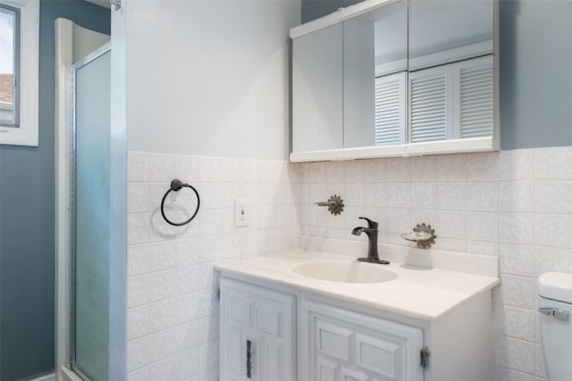 bathroom with a shower with door, vanity, and toilet