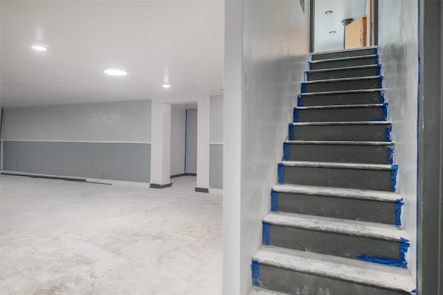 stairs featuring concrete flooring