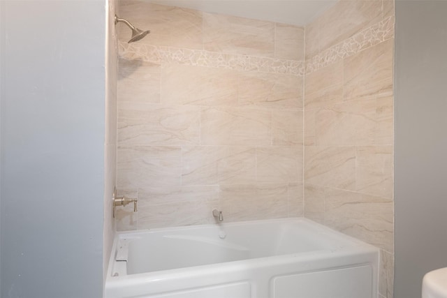 bathroom featuring bathtub / shower combination and toilet