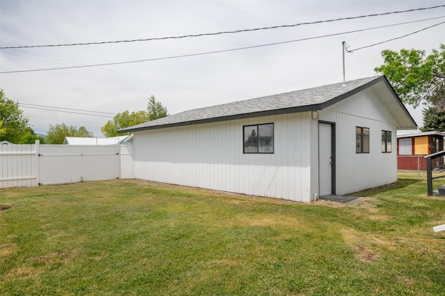 view of side of home featuring an outdoor structure and a yard