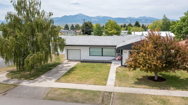 view of front of house with a mountain view, a garage, and a front yard