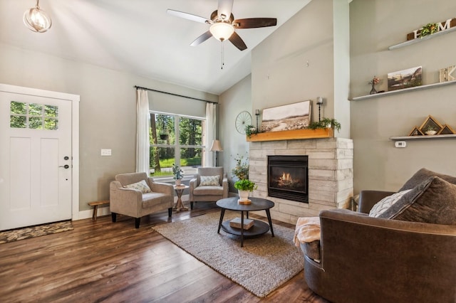 living room with a stone fireplace, dark wood-type flooring, high vaulted ceiling, and ceiling fan