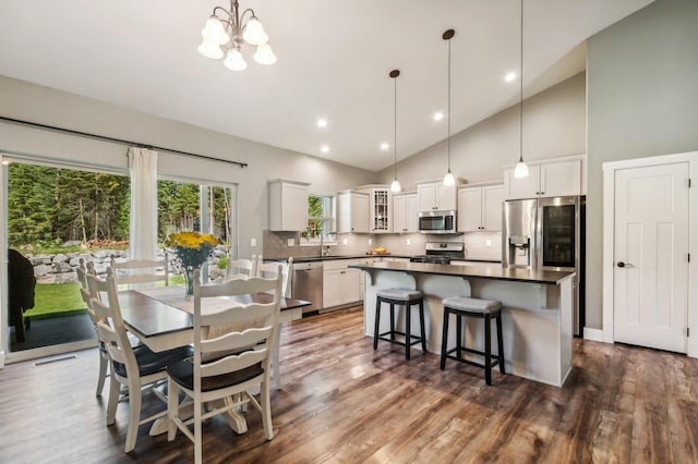 dining room with dark hardwood / wood-style floors and high vaulted ceiling