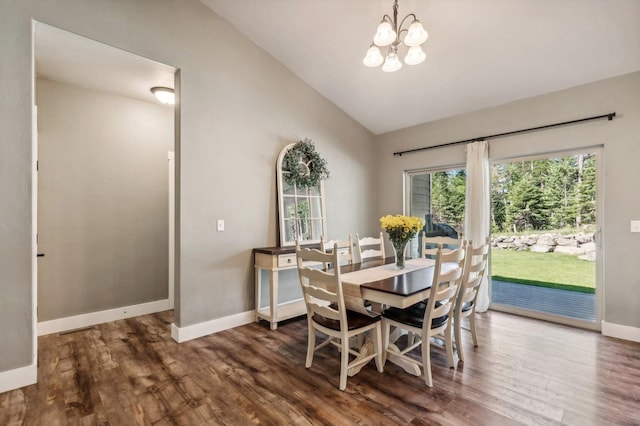 dining space with hardwood / wood-style flooring, lofted ceiling, and a notable chandelier