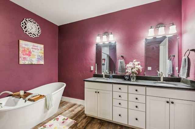 bathroom with hardwood / wood-style flooring, a bathing tub, and vanity