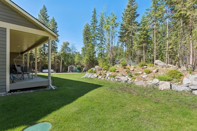 view of yard with a shed and a wooden deck