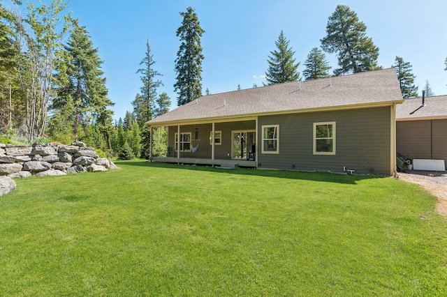 rear view of property featuring a yard