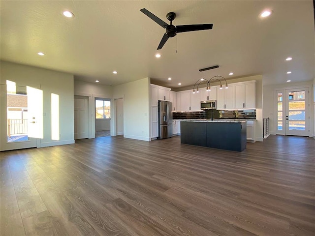 unfurnished living room with dark hardwood / wood-style floors, french doors, and ceiling fan