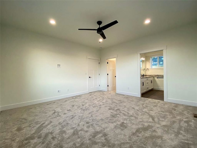 unfurnished bedroom featuring carpet floors, ensuite bath, and ceiling fan