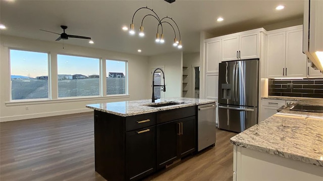 kitchen with a kitchen island with sink, ceiling fan, sink, and stainless steel appliances