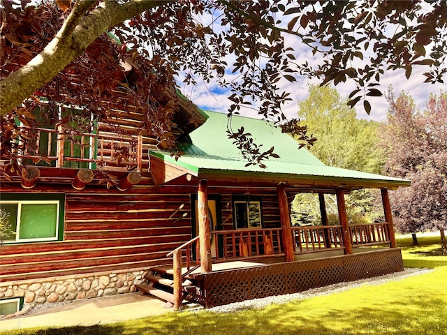 back of house with covered porch and a lawn