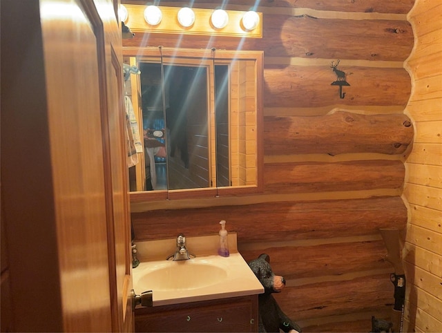 bathroom with vanity and log walls