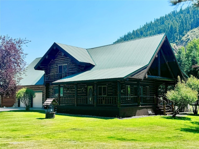 rear view of house featuring a mountain view, a yard, and covered porch