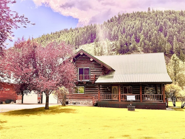 log home with a garage, a yard, and covered porch