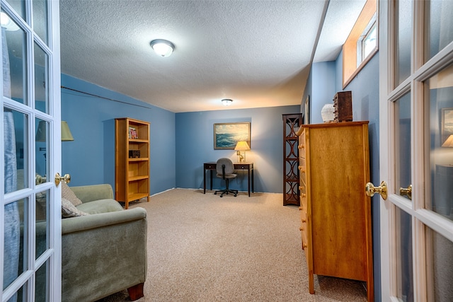 office area featuring a textured ceiling, carpet flooring, and french doors