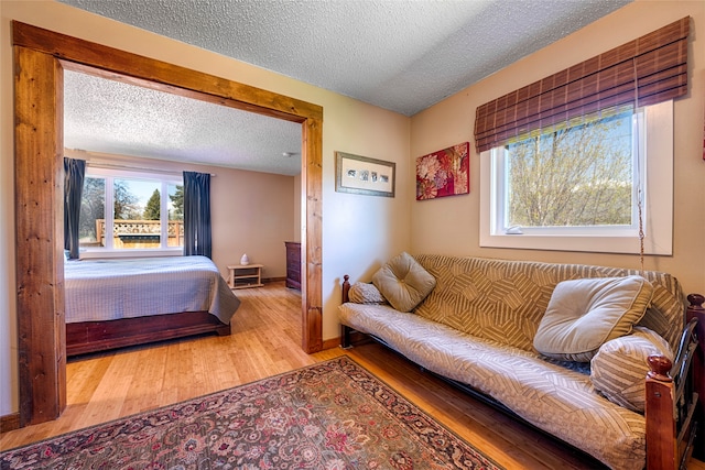 bedroom featuring light hardwood / wood-style floors and a textured ceiling