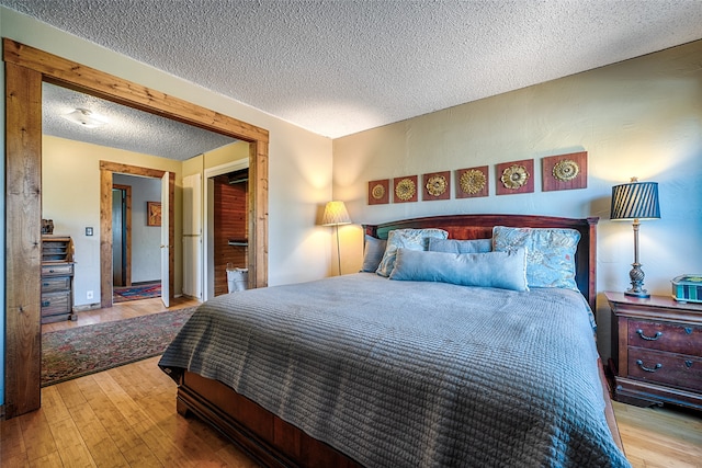 bedroom featuring a textured ceiling and light hardwood / wood-style floors