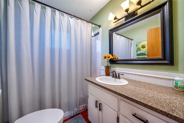 bathroom with vanity, a textured ceiling, toilet, and a shower with curtain