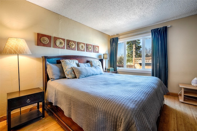 bedroom with wood-type flooring and a textured ceiling