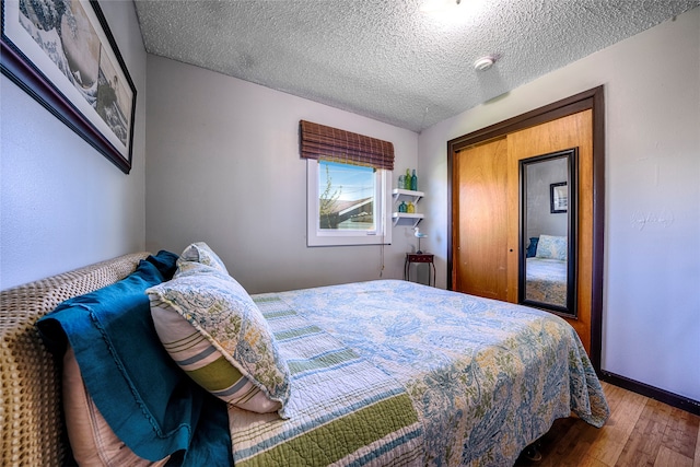 bedroom with wood-type flooring and a textured ceiling