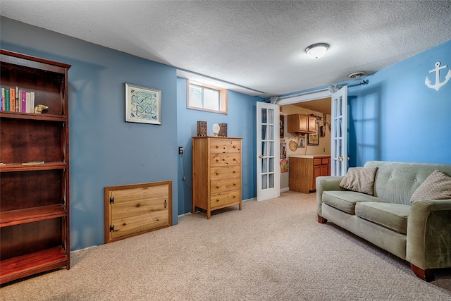 living area featuring a textured ceiling, french doors, and carpet