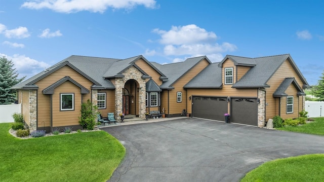 282 Mcwenneger Dr, Kalispell, MT 59901 - craftsman-style home featuring stone siding, an attached garage, asphalt driveway, and roof with shingles