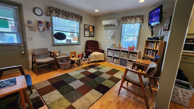 living area featuring an AC wall unit and wood-type flooring