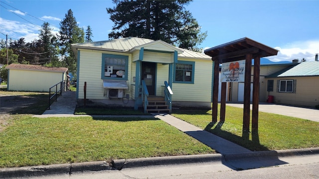 view of front facade featuring a front lawn and an outbuilding