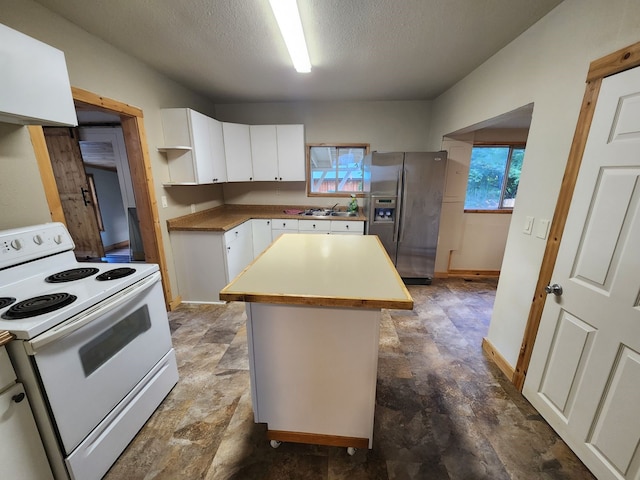 kitchen featuring white electric stove, white cabinets, tile patterned floors, stainless steel fridge with ice dispenser, and a center island