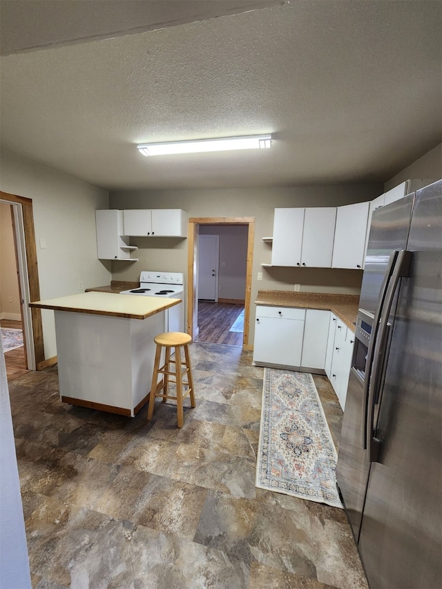 kitchen featuring a breakfast bar, a textured ceiling, white cabinets, hardwood / wood-style flooring, and stainless steel refrigerator with ice dispenser