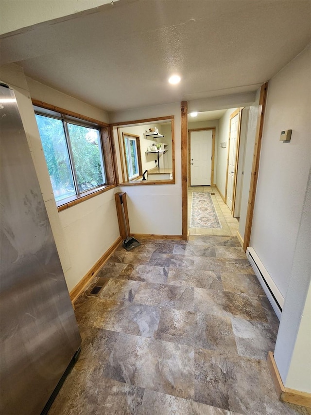 213 Washington St, Thompson Falls, MT 59873 - hall featuring visible vents, baseboards, stone finish flooring, and a baseboard radiator