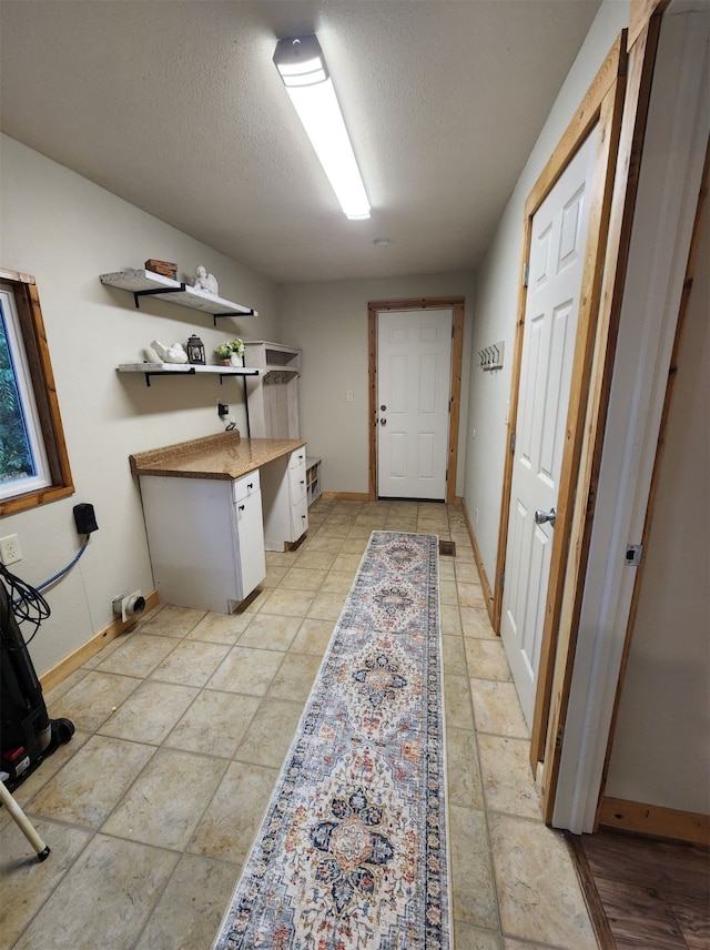 laundry area featuring light tile patterned floors and a textured ceiling