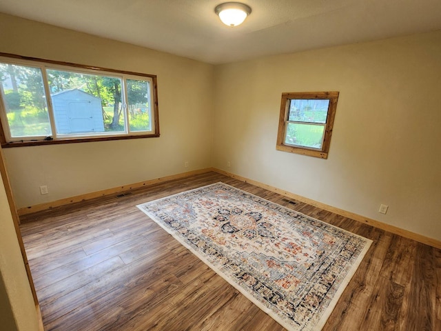 213 Washington St, Thompson Falls, MT 59873 - unfurnished room with baseboards, wood finished floors, and a healthy amount of sunlight