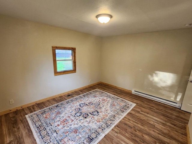 213 Washington St, Thompson Falls, MT 59873 - unfurnished room featuring a baseboard heating unit, baseboards, and wood finished floors