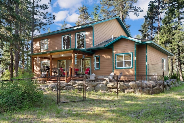 rear view of house featuring covered porch and a yard