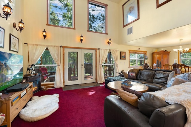 living room featuring a chandelier, a high ceiling, carpet flooring, and french doors