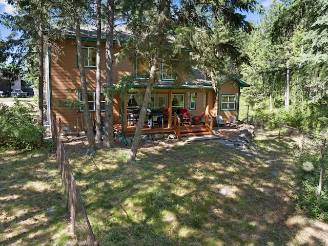 back of house with a lawn and a deck