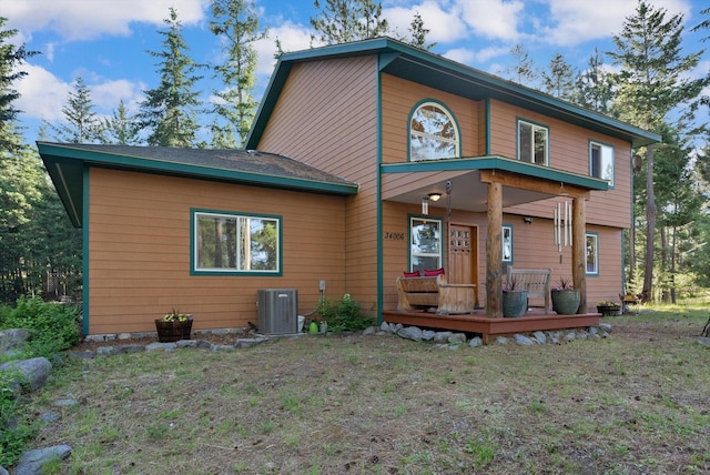 rear view of property with a yard and central AC